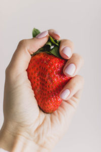 une main qui tient une fraise
