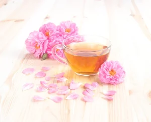 une tasse de tisane entourée de belles fleurs roses
