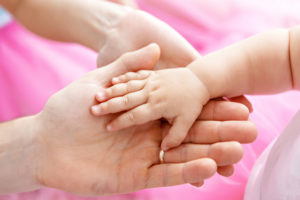 Main d'un bébé dans la main d'un adulte