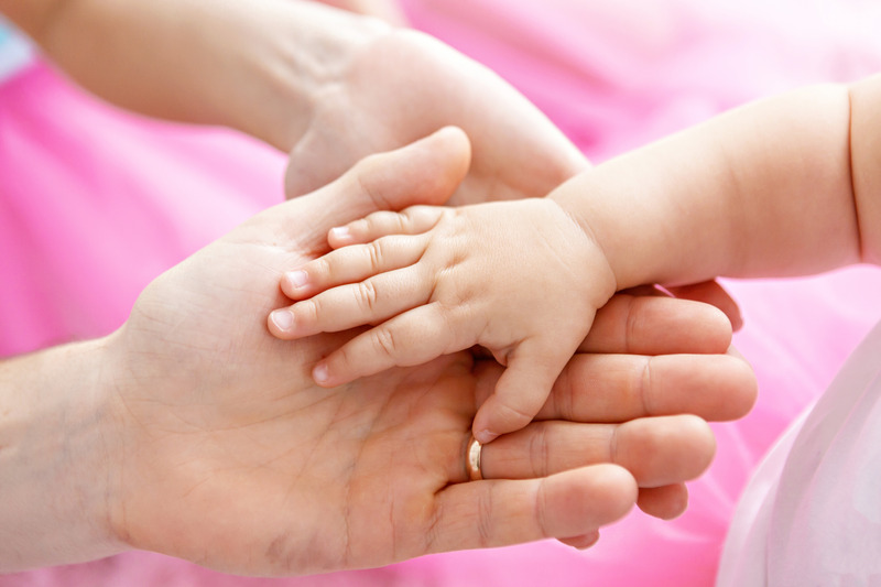 Main d'un bébé dans la main d'un adulte